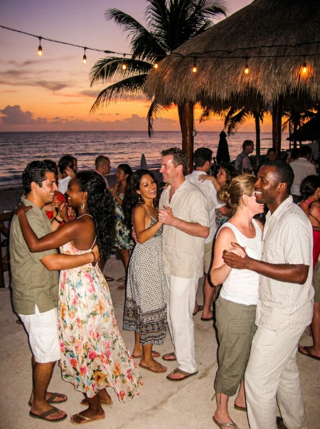 Couples dancing bachata on the beach at dusk