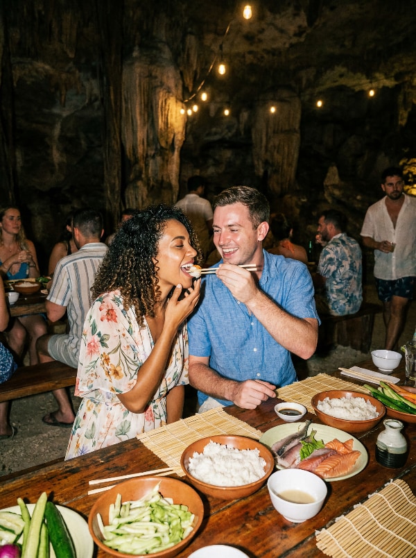 A sushi class at a long table inside a cenote