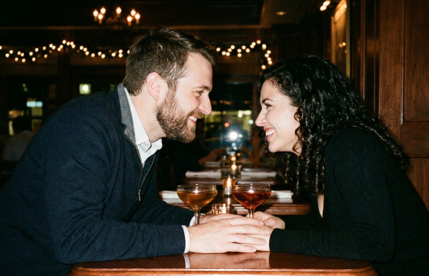 Two people talking closely at a candlelit table